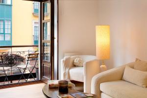 a living room with a couch and a chair and a table at Dúplex Casco Histórico-Catedral Parking incluido in Oviedo