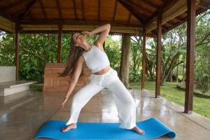a woman doing a yoga pose on a yoga mat at Maya Tangalle Luxury Wellness-Adults Only-Free Unlimited Shuttle service to our private Beach in Tangalle