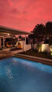 une piscine dans une maison avec un ciel rouge dans l'établissement Cottonwood Villa Samani Pool HOT-Jacuzzi Billyard, à Bandung