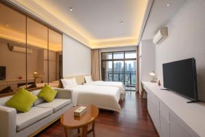 Una habitación de hotel con dos camas y un televisor. en 伊莲萨维尔酒店, en Guangzhou