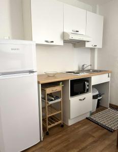 a kitchen with a white refrigerator and a sink at SAINT-FLORENT Studio PISCINE FLO300-146 in Saint-Florent