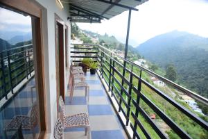 a balcony with chairs and a view of mountains at Naturehunt homestays in Kodaikānāl