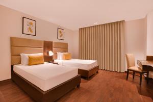 Postel nebo postele na pokoji v ubytování Lemon Tree Hotel, Noida