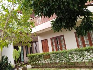 a house with trees in front of it at เดอะนิรันดร์ เกสท์เฮ้าส์กาญจนบุรี in Ban Chuk Yai Yuan