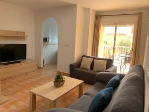 a living room with a couch and a table at Brisas del mar in Puerto de Mazarrón +56 photos
