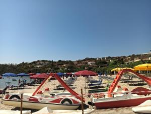 un grupo de barcos en una playa con sombrillas en Tortolì-Porto Frailis-Arbatax, en Àrbatax