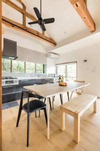 a kitchen with a table and a ceiling fan at 九十九里 一棟貸 BBQ無料 ジャグジー サウナ 焚火 Re Base Shirako in Shirako