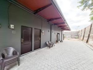 a group of benches sitting on the side of a building at Homestay Sido Joyo near Sunrise Mall Mitra RedDoorz in Mojokerto
