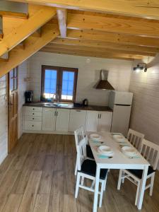 a kitchen with a table and chairs in a room at Domki Letniczówka Kołobrzeg nad morzem in Grzybowo +28 photos