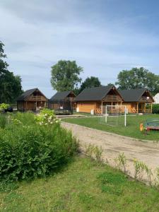 a group of houses with a dirt road in front at Domki Letniczówka Kołobrzeg nad morzem in Grzybowo