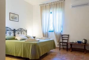 een slaapkamer met een groen bed en een raam bij Tenuta Badessa in Casalabate