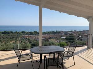 a table and chairs on a porch with a view at VILLA ARCANGELO Le in Mandatoriccio Marina