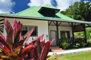 a small white house with a green roof at La Bel Zilwaz Guesthouse in La Digue