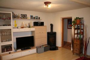 ein Wohnzimmer mit einem Flachbild-TV und einem Kamin in der Unterkunft Eggerhof in Neustift im Stubaital