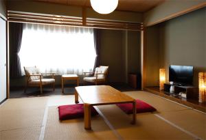 un soggiorno con un tavolo e una televisione di ビューリゾートインとみや a Yuzawa