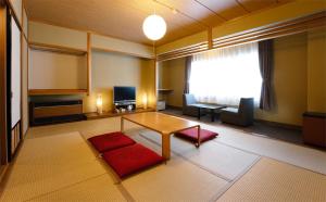 un soggiorno con tavolo e tappeto rosso di ビューリゾートインとみや a Yuzawa