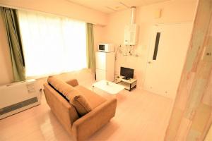 a living room with a couch and a television at E-Horizon北2条ビル in Sapporo