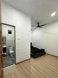 a room with a toilet and a ceiling fan at Cinematic Home Stay in Ulu Choh Village