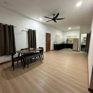 a living room with a table and a ceiling fan at Cinematic Home Stay in Ulu Choh Village