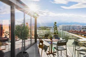 Un patio con una mesa y sillas en un balcón. en Stay KooooK Geneva City - Online Check In, en Ginebra