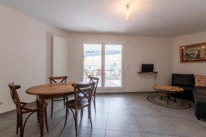 Una sala de estar con una mesa y sillas de madera. en La Providence, en Annecy