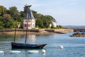un barco en el agua frente a una casa en Appartement 400m du port, en Douarnenez