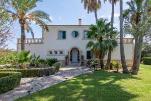 an exterior view of a house with palm trees at Villa Fina in Colònia De Sant Jordi