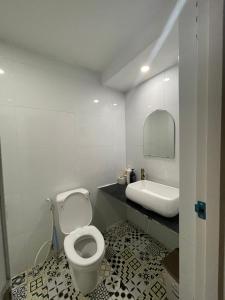 a white bathroom with a toilet and a sink at Chang ơi homestay Sai Gon in Ho Chi Minh City