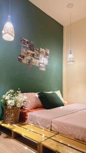 a bedroom with a bed and a green wall at Chang ơi homestay Sai Gon in Ho Chi Minh City