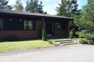 a small brick house with a porch and a driveway at Kotimaailma Apartments - Cozy and spacious house in Naantali