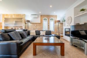 a living room with a leather couch and a coffee table at Villa Fina in Colònia De Sant Jordi