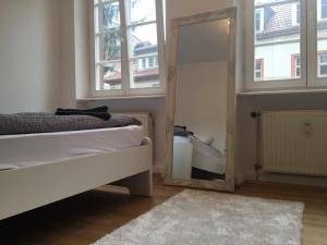 um quarto com um espelho, uma cama e uma janela em Im Herzen der Altstadt em Heidelberg