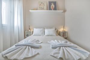 - une chambre blanche avec 2 serviettes sur un lit dans l'établissement El Oasis de San Pedro, à Cordoue