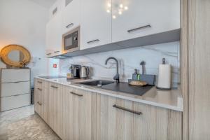 une cuisine avec un évier et un micro-ondes dans l'établissement El Oasis de San Pedro, à Cordoue