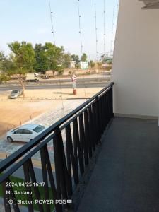 a balcony with a car parked next to a building at Sree Durga Hotel Ramsons International in Mysore