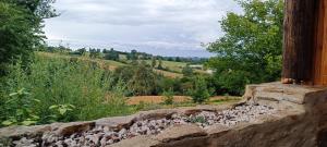 a stone wall with a view of a field at La chouette in La Malonie +2 photos