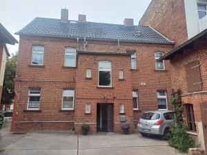a brick house with a car parked in front of it at Ferienwohnung Köppe in Lutherstadt Wittenberg