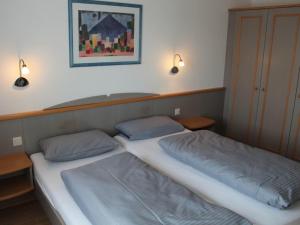 deux lits dans une chambre avec des lumières sur le mur dans l'établissement Ferienhaus Nr 38, Kategorie Komfort, Feriendorf Hochbergle, Allgäu, à Lechbruck am See