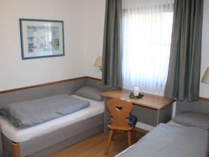 une chambre avec deux lits et un bureau et une fenêtre dans l'établissement Ferienhaus Nr 38, Kategorie Komfort, Feriendorf Hochbergle, Allgäu, à Lechbruck am See 13 autres photos