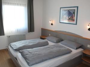 une chambre avec deux lits et une fenêtre dans l'établissement Ferienhaus Nr 38, Kategorie Komfort, Feriendorf Hochbergle, Allgäu, à Lechbruck am See