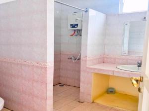 Villa Luxury kota bunga في Cikundul: حمام وردي مع دش ومغسلة +6 صور