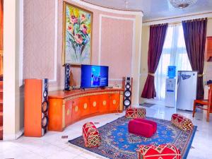 Villa Luxury kota bunga في Cikundul: غرفة معيشة مع تلفزيون بشاشة مسطحة على الحائط