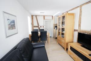 a living room with a black couch and a television at Haart & Soul Guesthouse in Piesport
