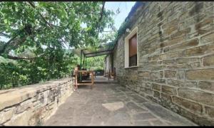 a stone house with a stone wall and a patio at Gest House Felau in Përmet