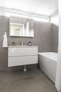 Private villa in central Östersund في أوسترسوند: حمام مع حوض وحوض استحمام ومرآة