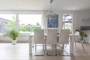 Private villa in central Östersund في أوسترسوند: غرفة طعام بيضاء مع طاولة وكراسي بيضاء