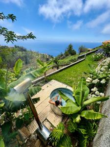 a hot tub in a garden with a view of the ocean at Meerblick - 3-Bett Villa mit Terrassen & Hot-Tub in Fajã da Ovelha