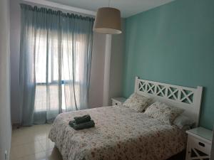 Un dormitorio con una cama y una ventana grande. en AMPLIO PISO EN COSTA BALLENA A 100 M DE LA PLAYA, en Costa Ballena