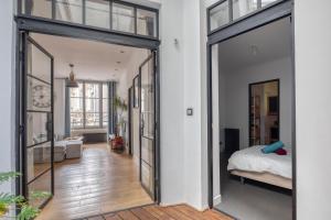 a bedroom with a bed and a large glass doorway at Appartement spacieux au cœur d'Angers étage 1 - 6 personnes in Angers