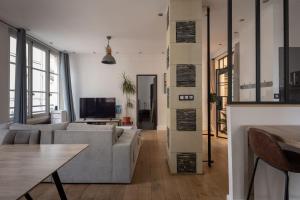 a living room with a couch and a tv at Appartement spacieux au cœur d'Angers étage 1 - 6 personnes in Angers